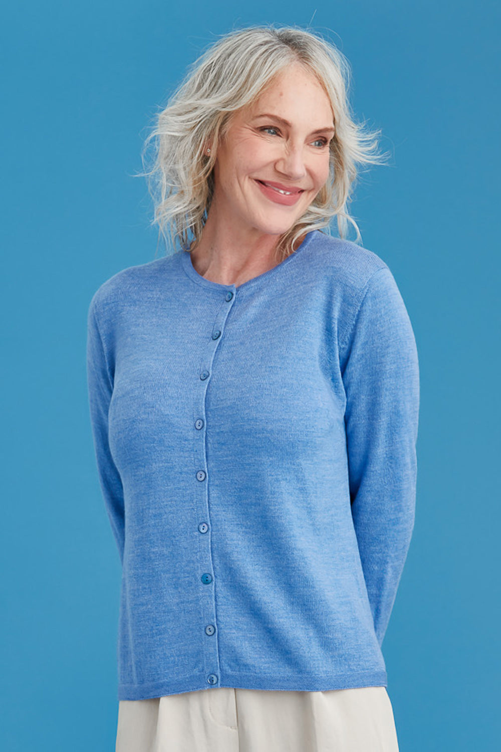 Woman wearing a blue cardigan against a blue background